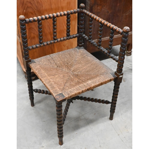 171 - A late Victorian bobbin turned corner chair with woven rush seat