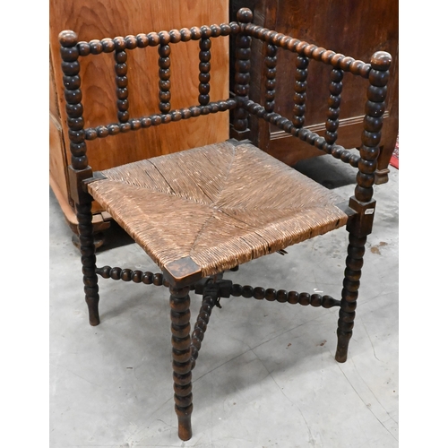 171 - A late Victorian bobbin turned corner chair with woven rush seat