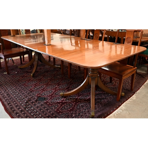 179 - A large Regency mahogany extending dining table with two central leaves, twin pedestal supports on o... 