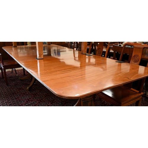 179 - A large Regency mahogany extending dining table with two central leaves, twin pedestal supports on o... 