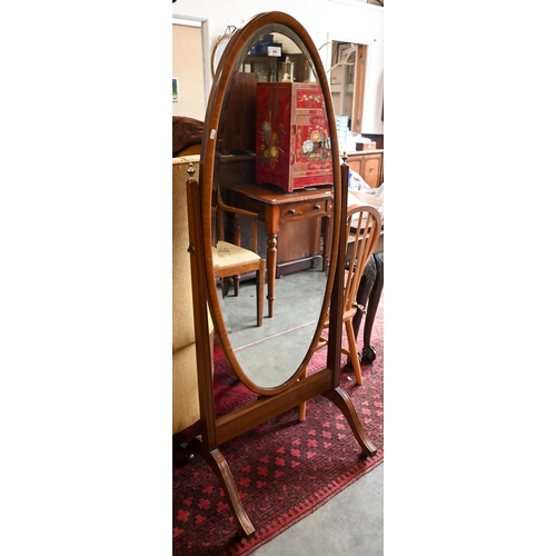 184 - A mahogany framed cheval mirror with bevelled oval plate and brass casters, 150 x 60 cm