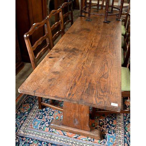 188 - An antique provincial refectory dining table on twin trestle supports united by jointed stretcher, 2... 