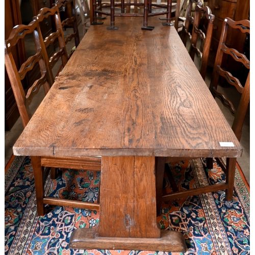 188 - An antique provincial refectory dining table on twin trestle supports united by jointed stretcher, 2... 