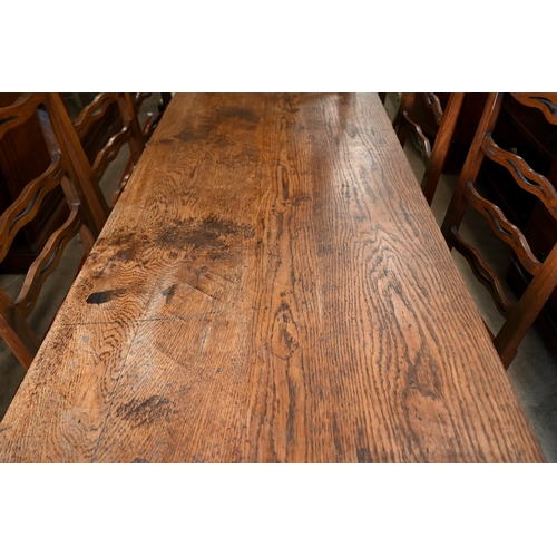 188 - An antique provincial refectory dining table on twin trestle supports united by jointed stretcher, 2... 