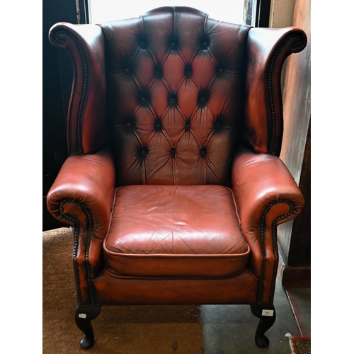 192 - A Georgian style wingback armchair, buttoned and studded leather upholstery and mahogany cabriole tr... 