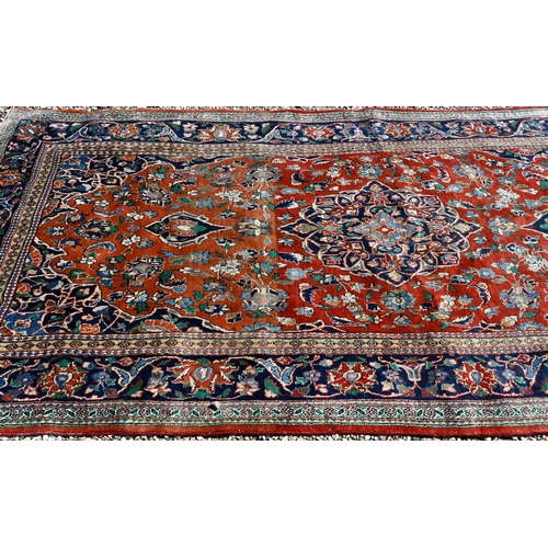 195 - A Persian Kelleigh carpet, of floral design on red ground, the blue border with repeating palmettes,... 