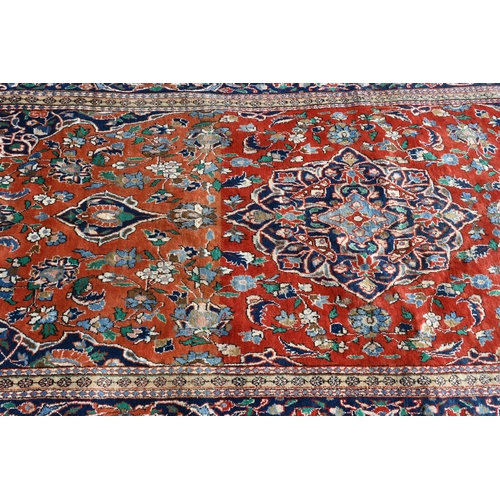 195 - A Persian Kelleigh carpet, of floral design on red ground, the blue border with repeating palmettes,... 