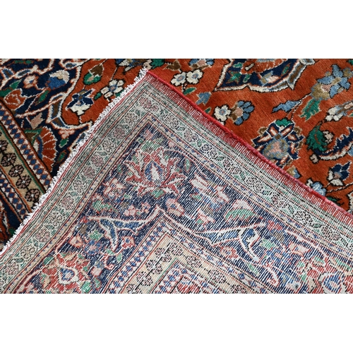 195 - A Persian Kelleigh carpet, of floral design on red ground, the blue border with repeating palmettes,... 