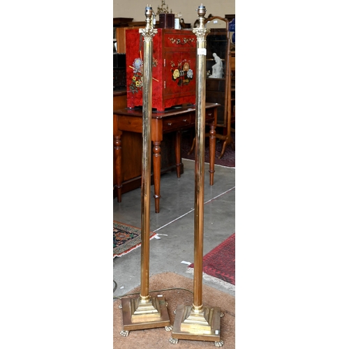 200 - A pair of classical column brass standard lamps on lion paw feet, 138 cm high