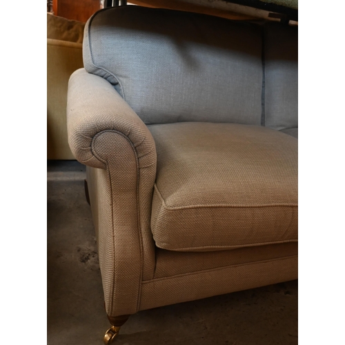 217 - Laura Ashley - a two-seater scroll arm sofa in stone linen-blend fabric on hardwood suports with bra... 