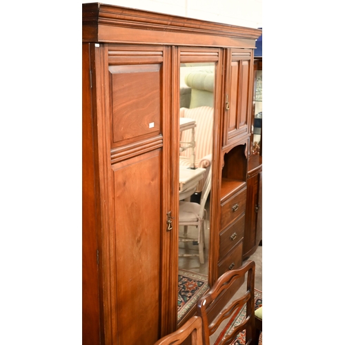 223 - An Edwardian walnut compactum wardrobe with mirrored door enclosing brass rail beside panelled cupbo... 