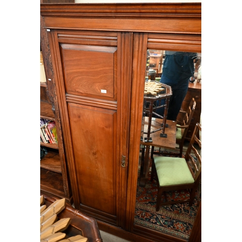 223 - An Edwardian walnut compactum wardrobe with mirrored door enclosing brass rail beside panelled cupbo... 