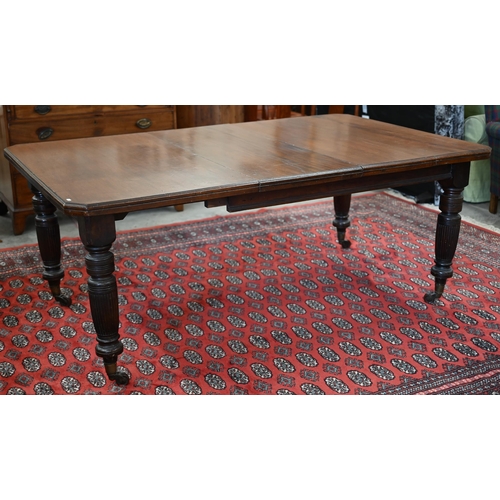 228 - An Edwardian mahogany extending dining table, wind-out canted rectangular top with single leaf on tu... 