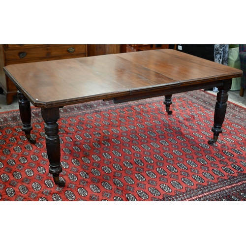 228 - An Edwardian mahogany extending dining table, wind-out canted rectangular top with single leaf on tu... 