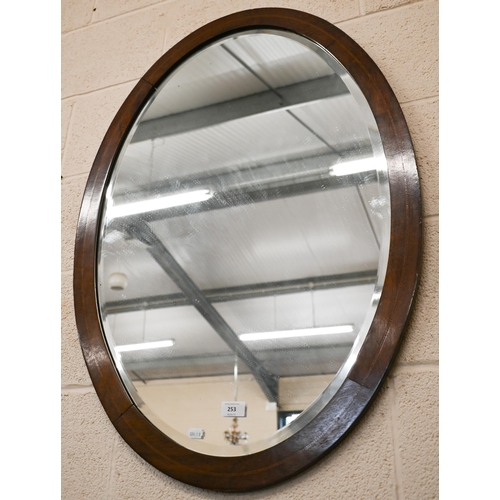 253 - An early 20th century bevelled oval mirror with inlaid mahogany frame, 90 x 66 cm