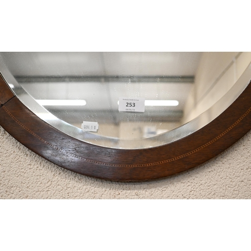 253 - An early 20th century bevelled oval mirror with inlaid mahogany frame, 90 x 66 cm