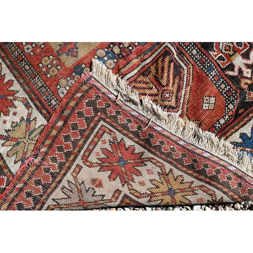 255 - An old Caucasian wide runner of geometric design on terracotta ground with cream border, 288 x 116 c... 