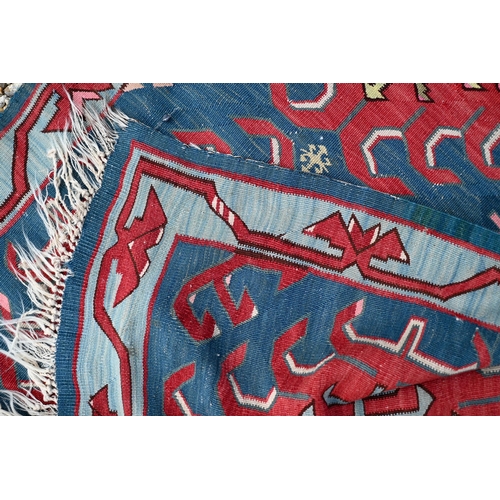 256 - A vintage Turkish Kilim, red 'hooked' medallions on blue field, 300 x 123 cm