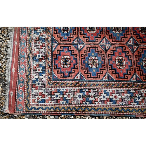 258 - A Turkish gul-tile design terracotta ground rug, cream repeating border, 210 x 130 cm