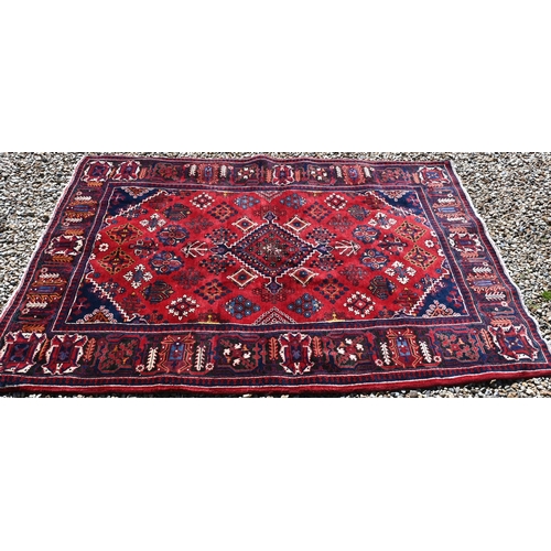 259 - A Persian Bijar rug, the central diamond medallion and floral motifs on red ground with dark blue bo... 