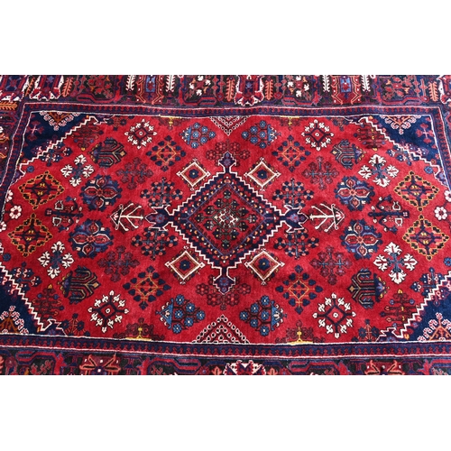 259 - A Persian Bijar rug, the central diamond medallion and floral motifs on red ground with dark blue bo... 