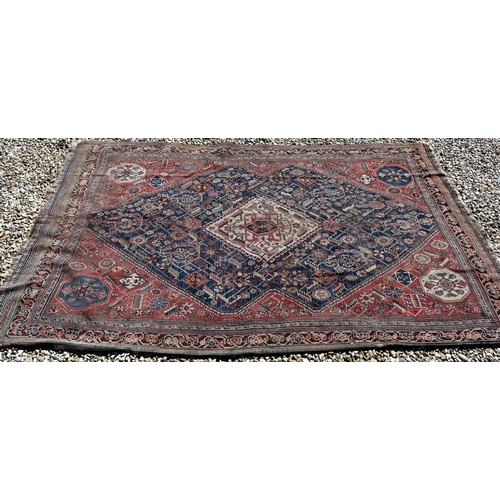 262 - A worn Persian Shiraz kelleigh rug, beige diamond medallion and stylised floral design on blue groun... 