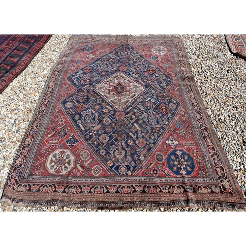 262 - A worn Persian Shiraz kelleigh rug, beige diamond medallion and stylised floral design on blue groun... 