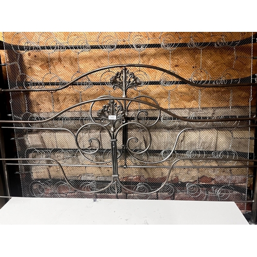 303 - An iron and brass kingsize (5ft) bed frame c/w sprung base