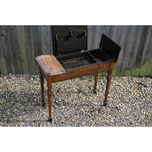 336 - An Arts & Crafts period oak triple fold over top desk, with interesting interior, raised on squa... 