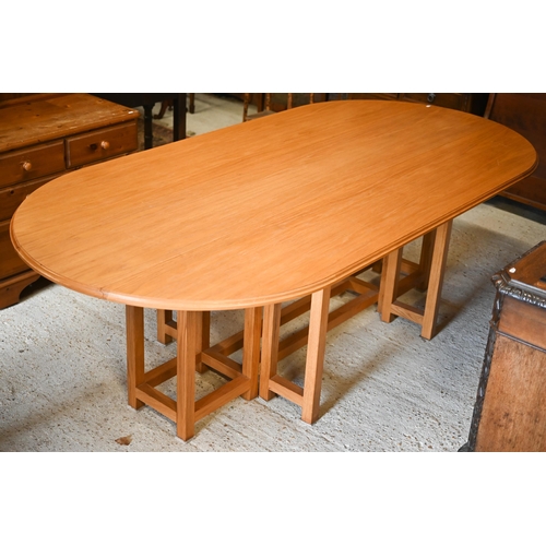 344 - A bespoke light oak dining table in wake style, the oval drop leaf top on double square section gate... 