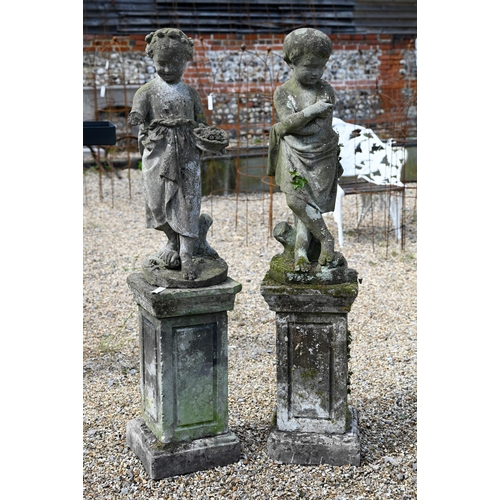 5 - A companion pair of old weathered cast stone garden statues, raised on three piece plinths, displayi... 