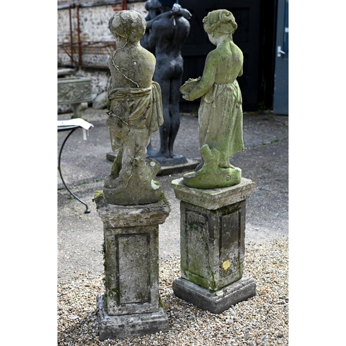 5 - A companion pair of old weathered cast stone garden statues, raised on three piece plinths, displayi... 