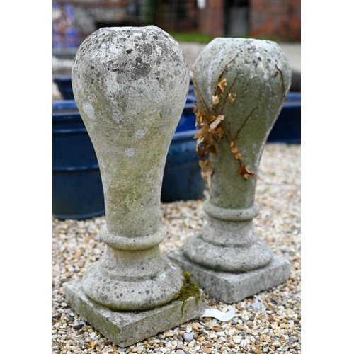 65 - A pair of weathered cast stone ball finials raised on associated square plinth bases (2)