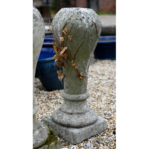 65 - A pair of weathered cast stone ball finials raised on associated square plinth bases (2)