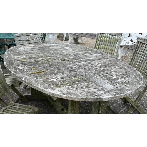 73 - A weathered teak garden table, oval to.wirh four folding chairs and another differing chair, all a/f... 