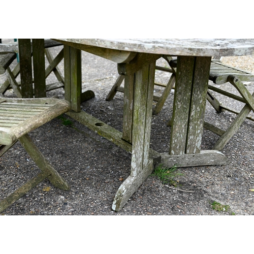 73 - A weathered teak garden table, oval to.wirh four folding chairs and another differing chair, all a/f... 