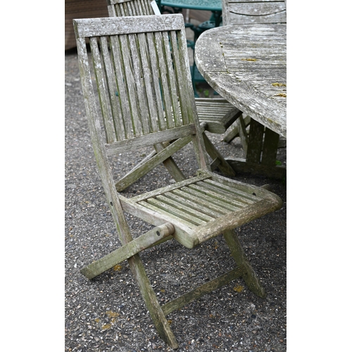 73 - A weathered teak garden table, oval to.wirh four folding chairs and another differing chair, all a/f... 