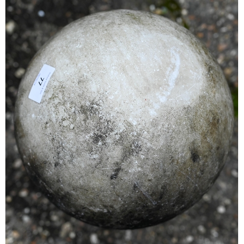 77 - A weathered marble ball finial on socle base, 24 cm dia. x 43 cm h