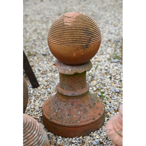 85 - Various assorted terracotta items, including a pair of ribbed ribbed spheres, a cast tulip vase urn ... 