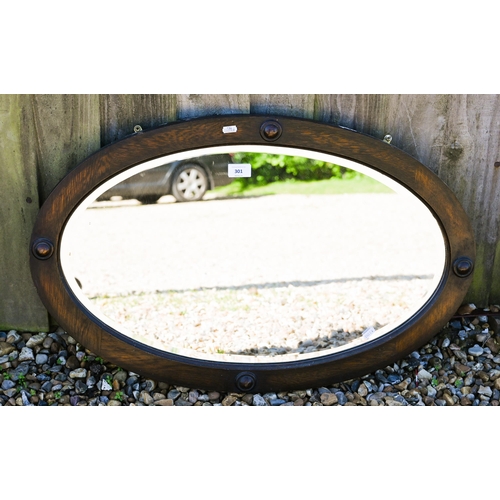 301 - # Three various bevelled wall mirrors in stained oak frames