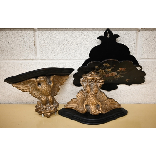 509 - A pair of ebonised and gilt composite wall brackets supported by spread eagles 31 cm wide, to/w a fo... 