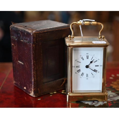 516 - A brass carriage clock, 14cm high overall, in leather case