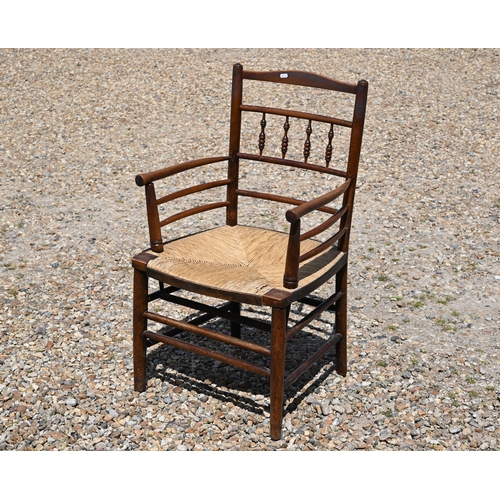 117A - An early 20th century stained beech Morris-type Sussex chair with woven rush seat