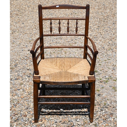 117A - An early 20th century stained beech Morris-type Sussex chair with woven rush seat