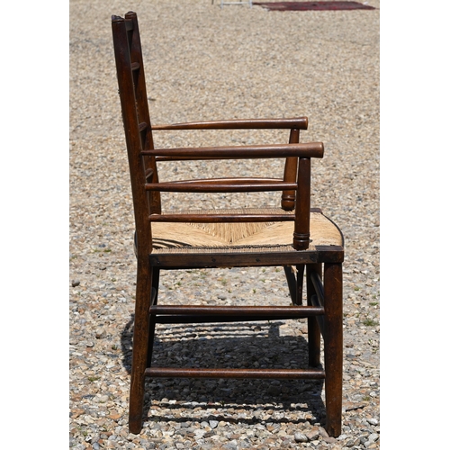 117A - An early 20th century stained beech Morris-type Sussex chair with woven rush seat