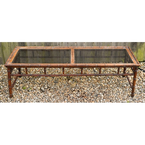 189A - A simulated bamboo rectangular coffee table with inset smoked glass panels, 148 x 54 x 44 cm high