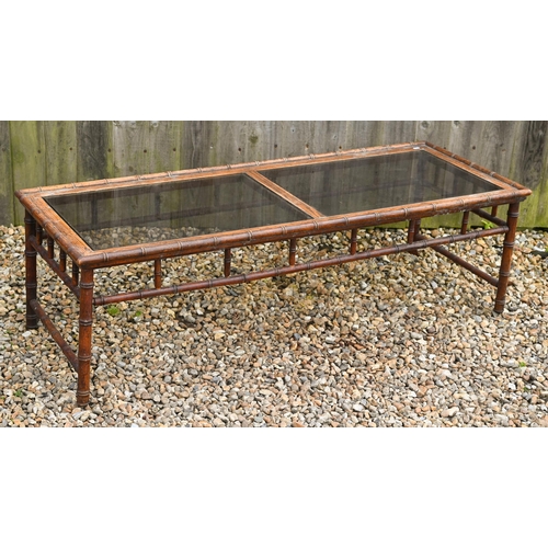 189A - A simulated bamboo rectangular coffee table with inset smoked glass panels, 148 x 54 x 44 cm high