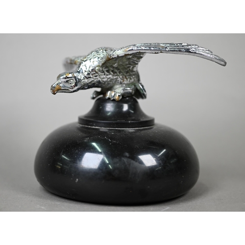 953 - A vintage chrome spread eagle car mascot, 4 cm high x 18 cm wingspan, mounted on a turned stone plin... 