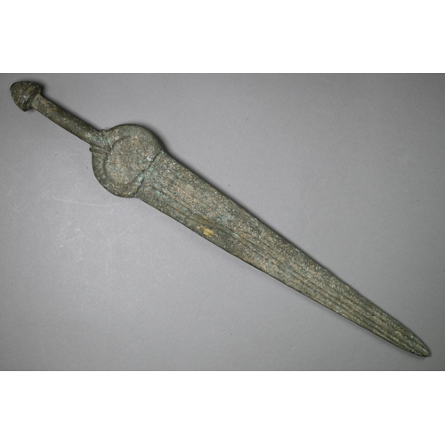 1004 - A Bronze Age sword, the tapering fullered blade with midrib, extending from oval shoulder, with colu... 