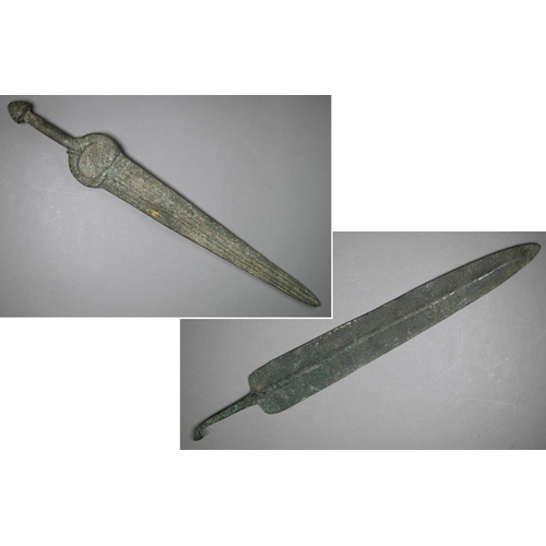 1004 - A Bronze Age sword, the tapering fullered blade with midrib, extending from oval shoulder, with colu... 